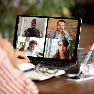 Remote meeting. Man working from home during coronavirus or COVID-19 quarantine, remote office concept. Young businessman, manager in front of monitor during online conference with colleagues and team.